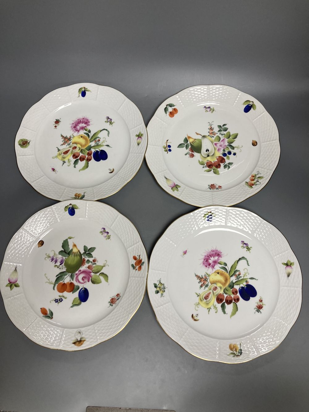 A set of four Herend Meissen style floral painted dessert dishes, diameter 25.5cm